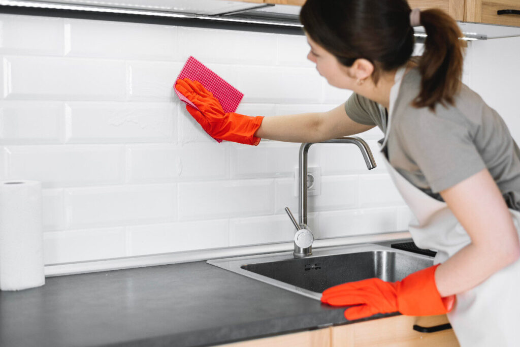 Profesional de aseo limpiando cocina en apartamento de Medellín