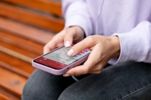 Persona usando una aplicación móvil para contratar servicio de aseo en Medellín